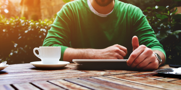 Man sitting at table holding tablet