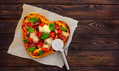 Heart-shaped pizza with pizza cutter